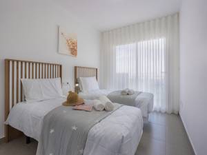Guest bedroom with white bedding and soft lighting.