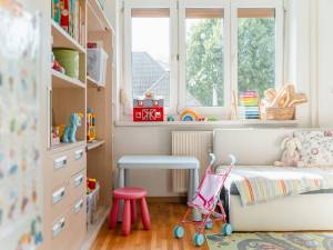 Children's bedroom with storage, bookshelves and toys.